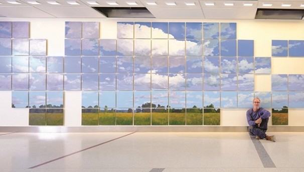 Individual sitting on the floor in front of the Breath of Hope Ohio mural