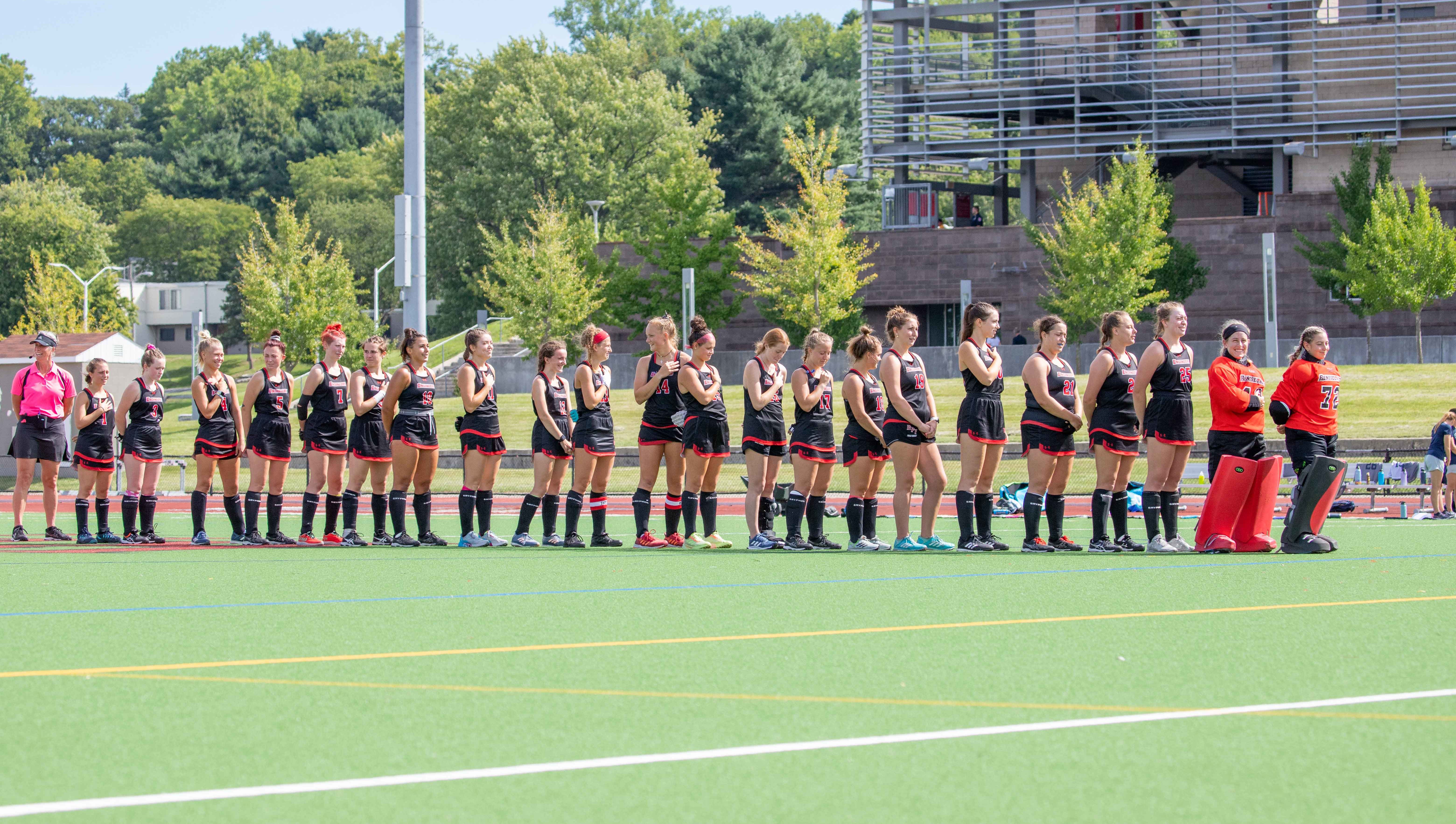 RPI Field Hockey players lined up on the field for the national anthem.