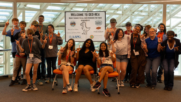 GEO-REx Summer 2025 campers giving a Go Pokes! in front of a Welcome to GEO-REx sign