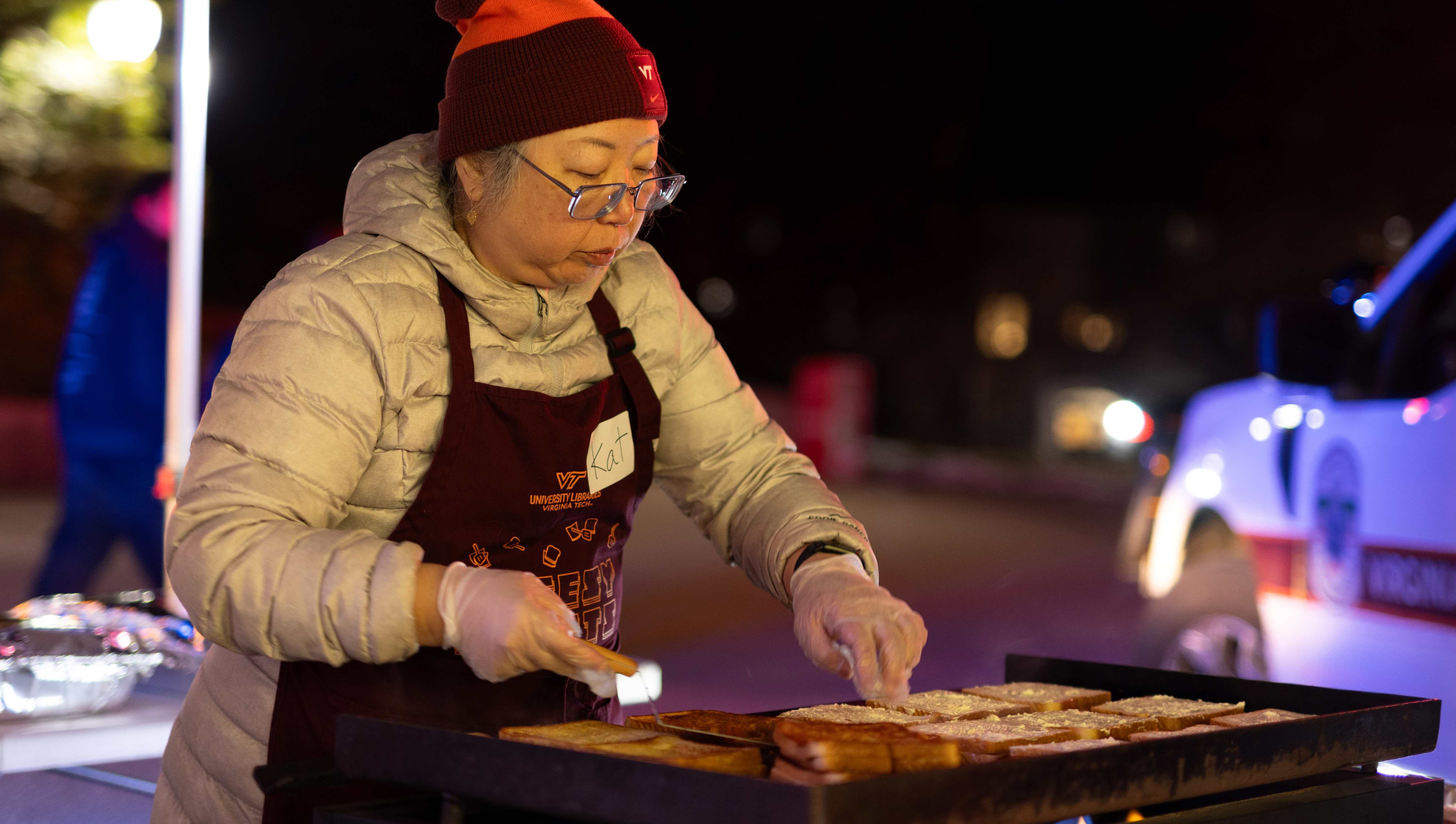 Volunteer grills sandwiches outside