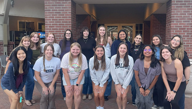 17 Kayette members pose together, with 10 in the back and 7 in front, smiling for the photo