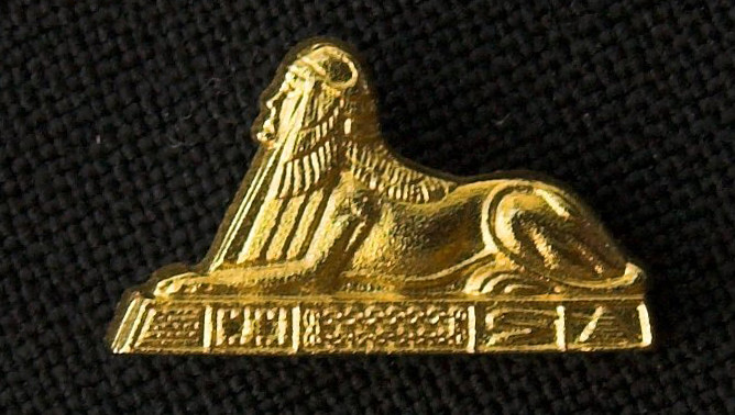 A group of individuals, most in graduation gear, holding up their pointer finger