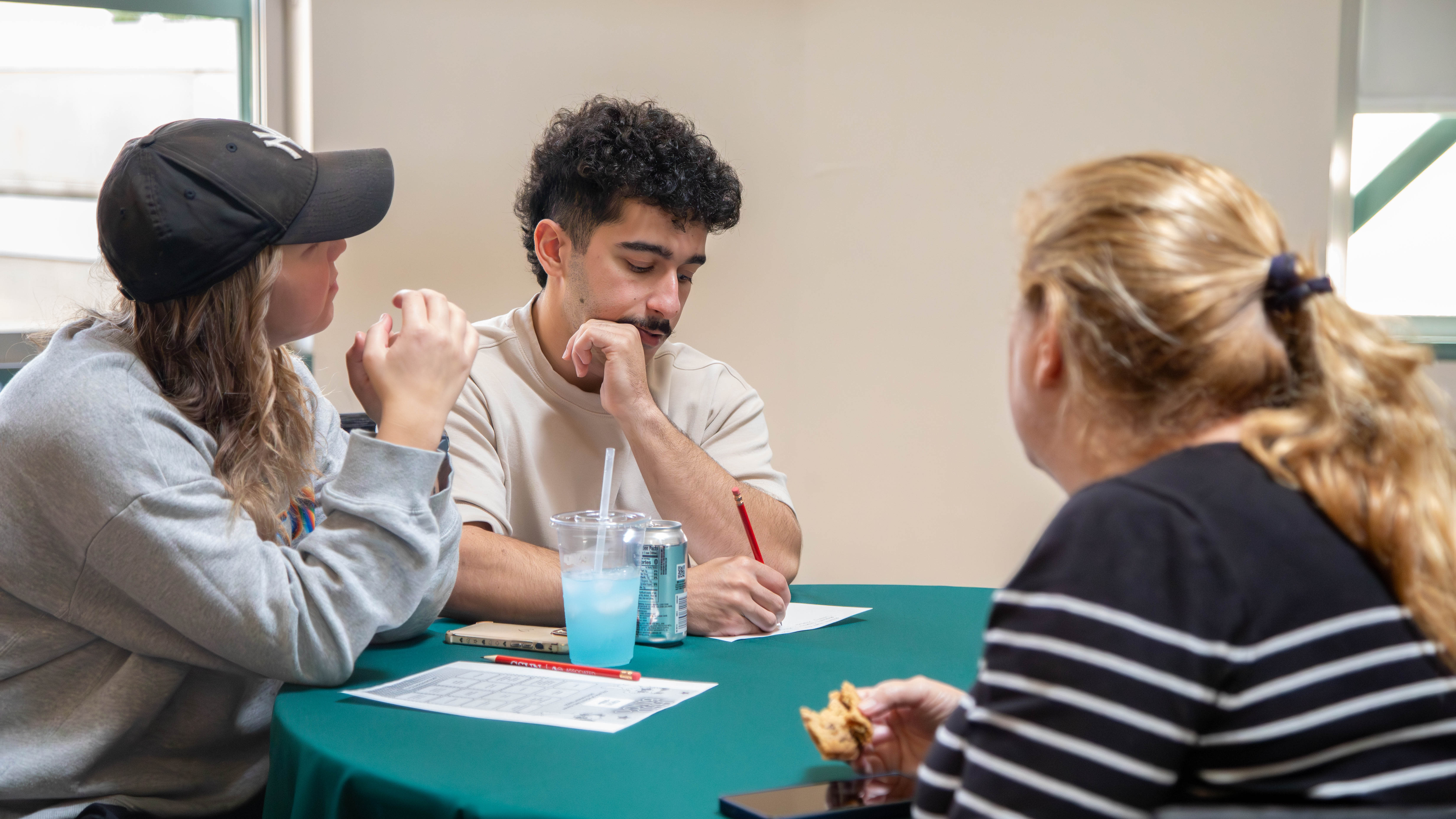 Students seated at a table, writing.