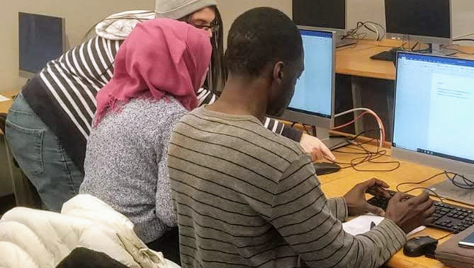 CBAEP students work together on a project on the computer.