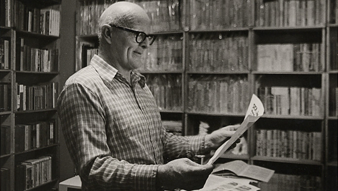 Individual reading a newspaper in an old library