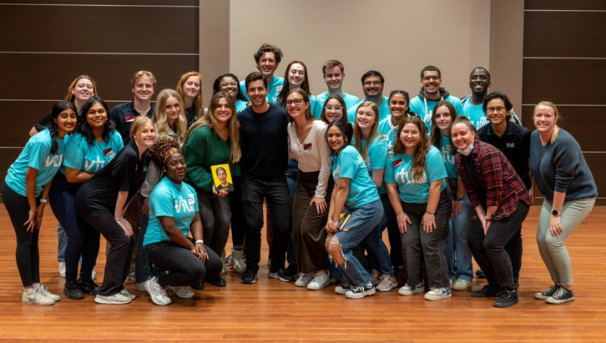 A group of Virginia Tech Union students stands and smiles with actor Josh Peck