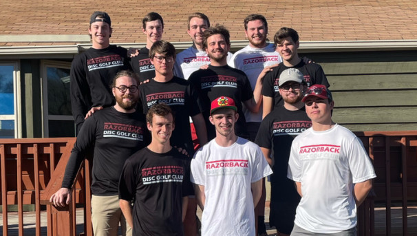 12 students standing together wearing Razorback Disc Golf Club shirts