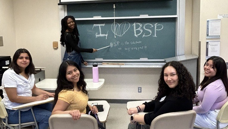 BSP students sitting in a room with "I love BSP!" written on a chalkboard.