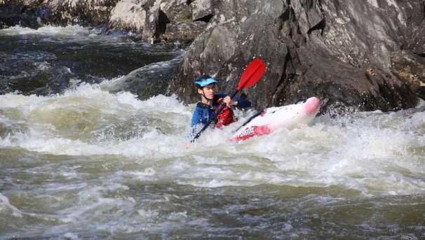 A student in a whitewater kayak