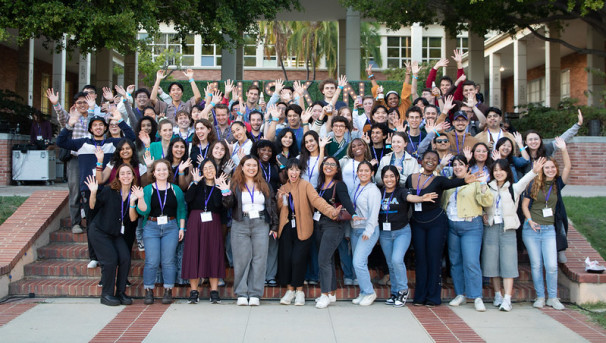 group of students poses outside Luskin on steps.