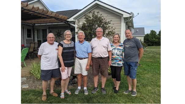 Dale Fahrenholz gathers with friends in front of a house.