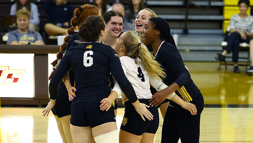 Women's Volleyball team celebrating on court