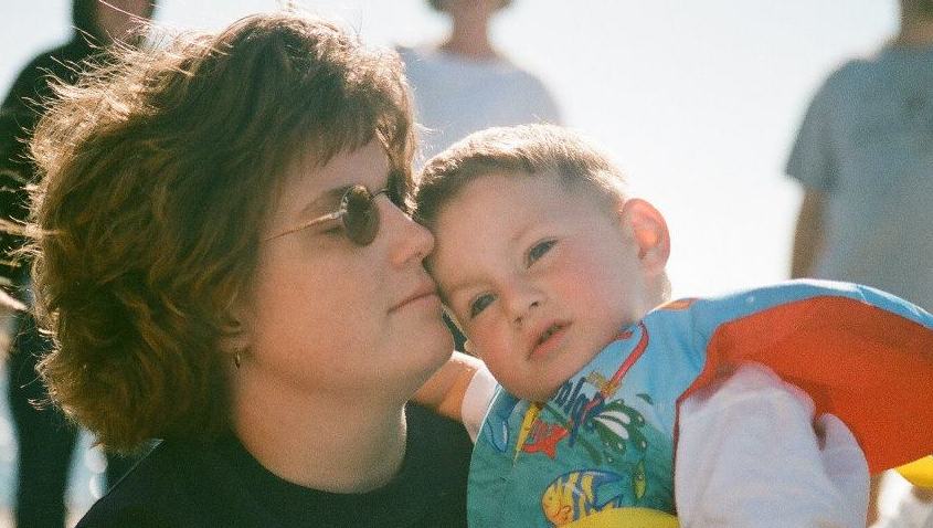 Barb holding a young Kevin. He wears a large, flotation vest