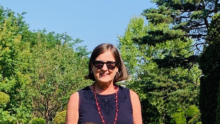 Becky posed for a picture in front of lush, green trees