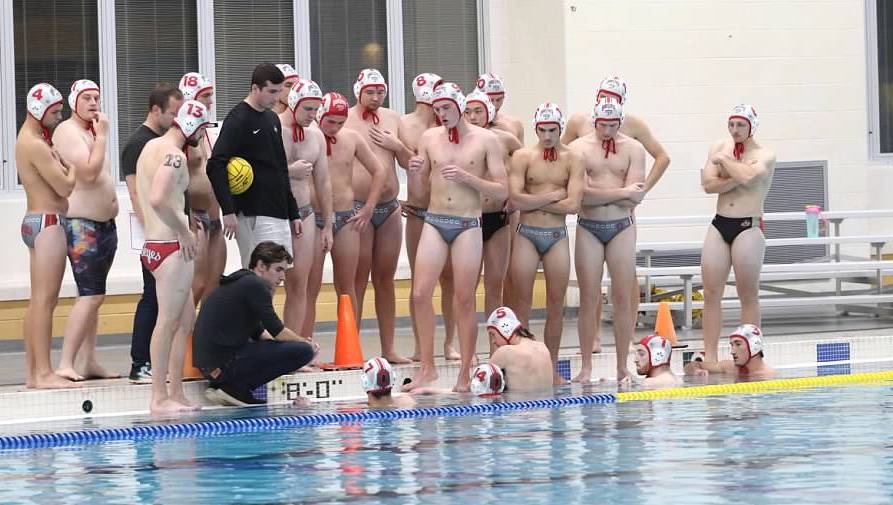 Group of Ohio State water polo players standing near the pool with their coaches