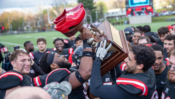 Members of the RPI football team holding up the Dutchman's Shoes trophy