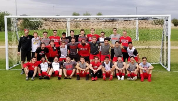 The 2018 Men's Club Soccer team in the field's goal.