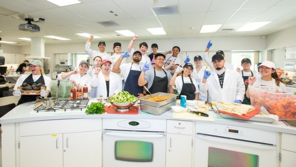 Students learning to cook in the demo kitchen.