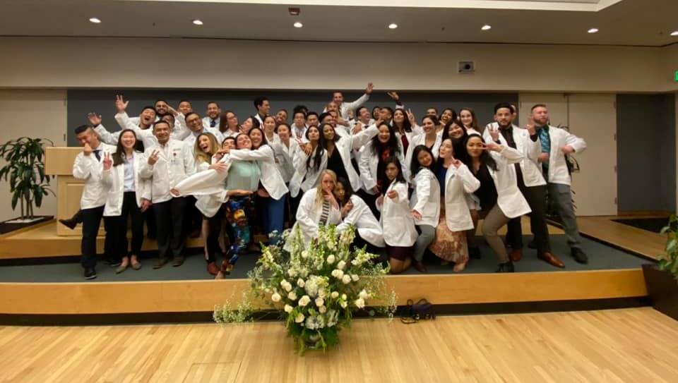 Group of students posing in their white coats.