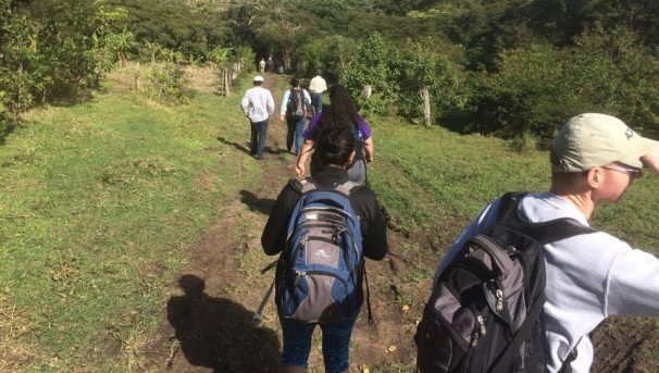 Students walking in a field while participating in an international project.