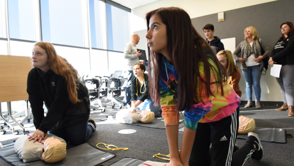 Students on a Simulation Center field trip practicing CPR on training mannequins.