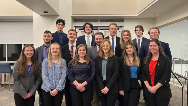 Members of Pi Sigma Epsilon pose for a photo in a classroom