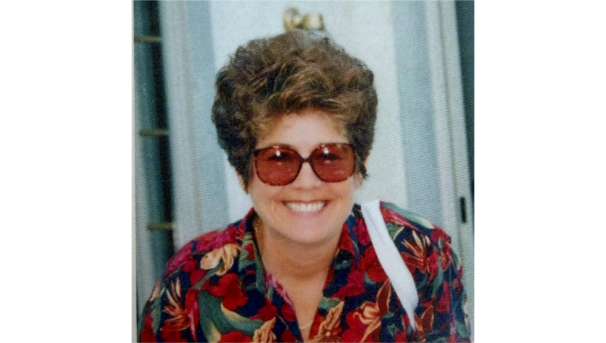 Nan Elaine Grandstaff smiling in red sunglasses