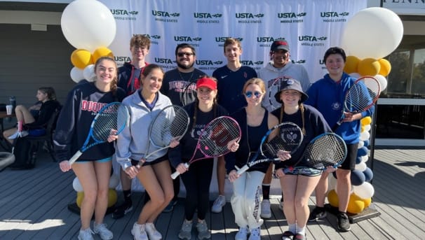 group of students smiling with tennis rackets