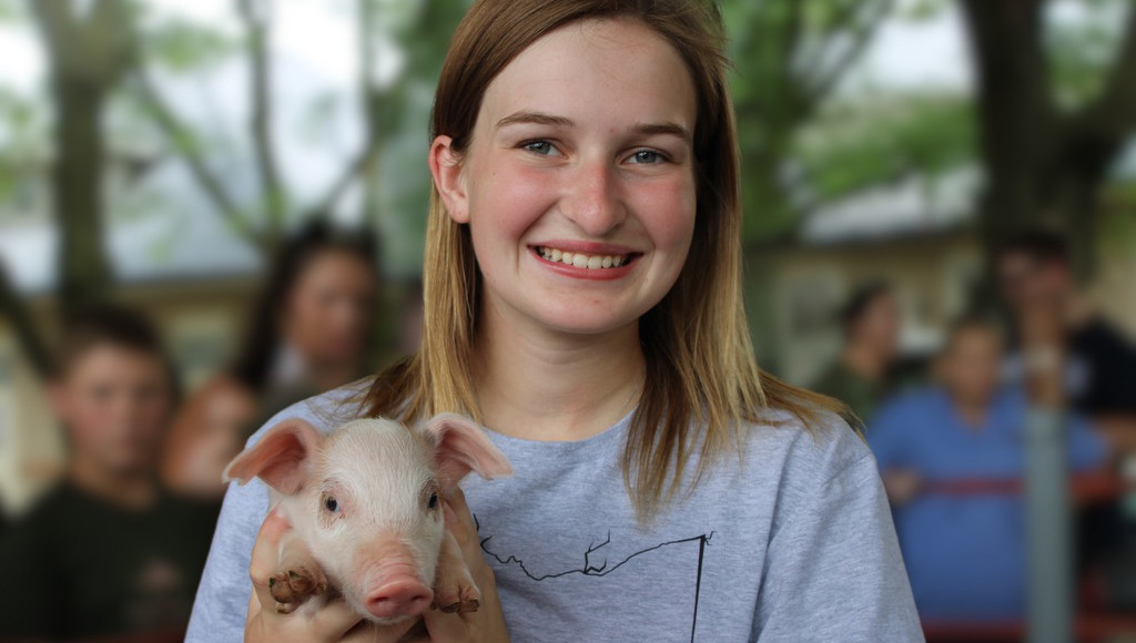 Gracie Sprague holding piglet