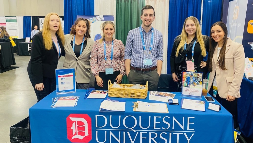 Students pose at Duquesne University table