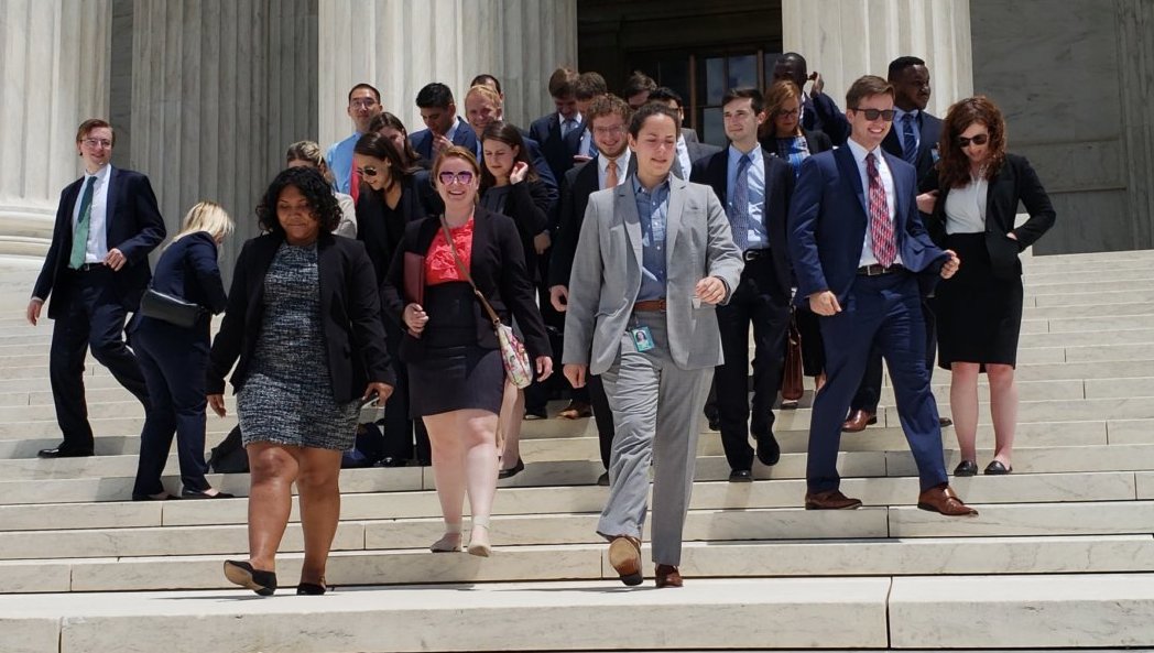 Buckeyes in Law at the Supreme Court, walking down the stairs. They all wear formal attire