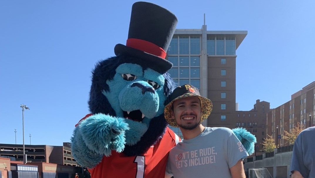 student smiling with the duquesne duke mascot