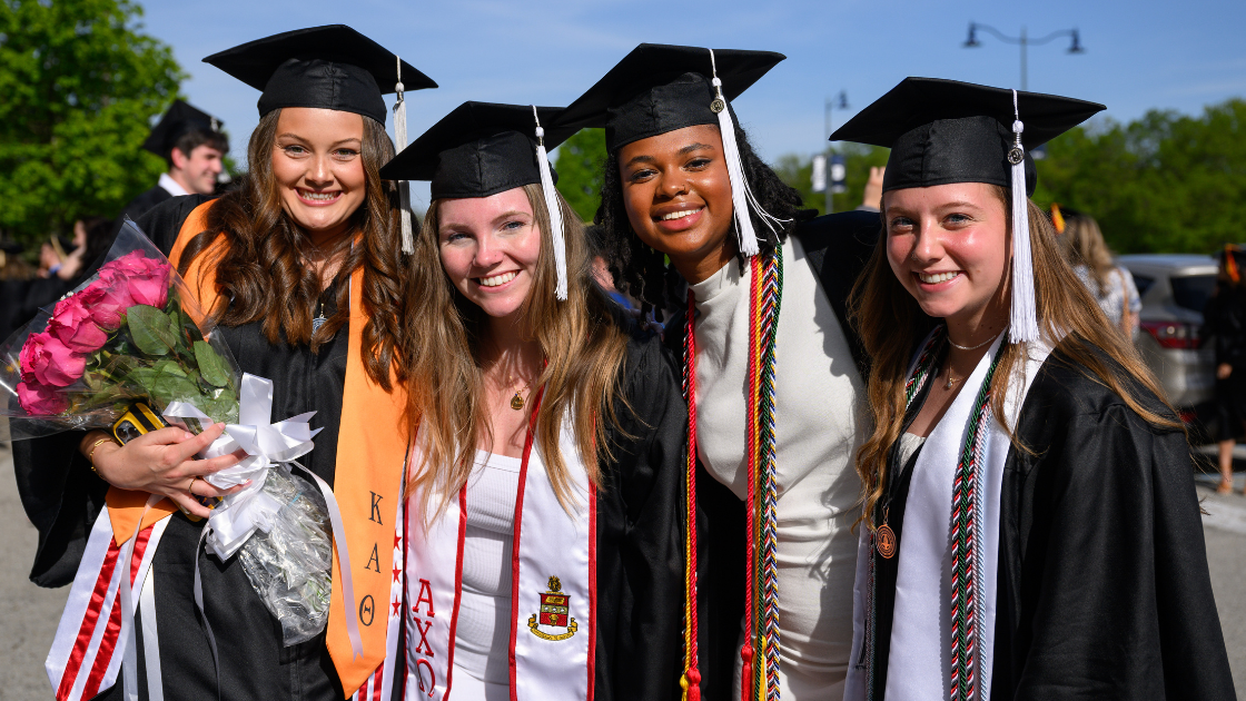 Four students gather after Commencement