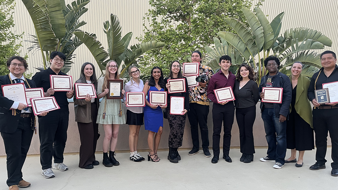 Student editors holding up certificates from the Journalism Awards