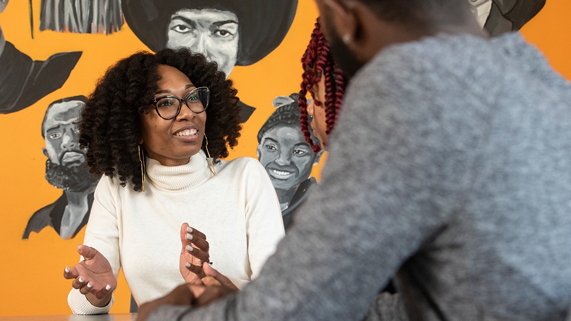 Group of students and administrators standing in a group, holding up posters of key individuals