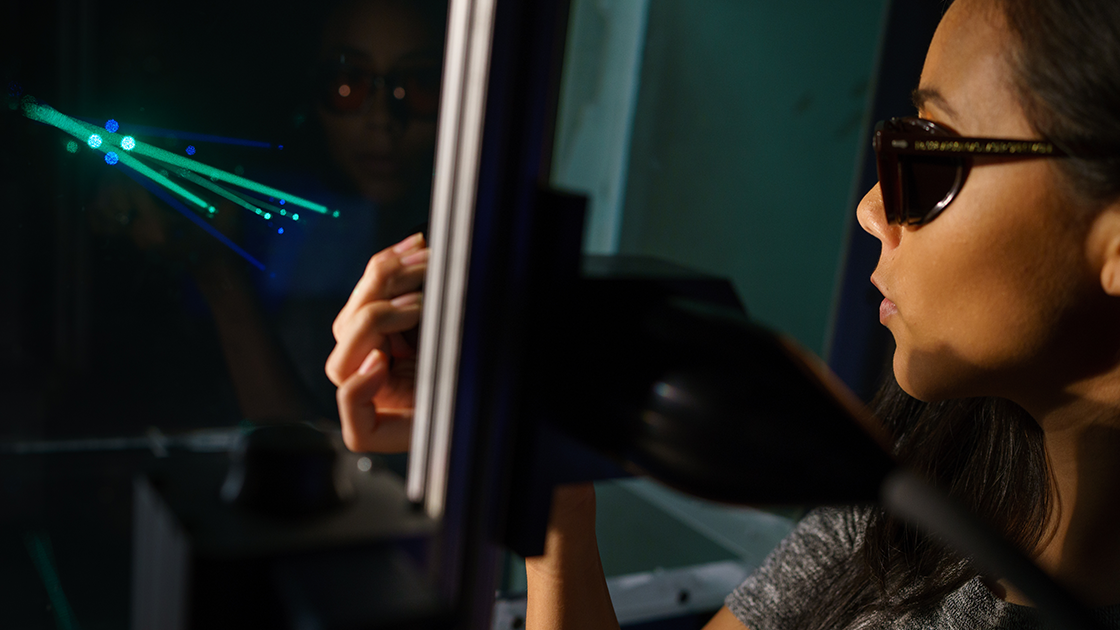 Student conducts laser-based research in CSUN optics and photonics lab.