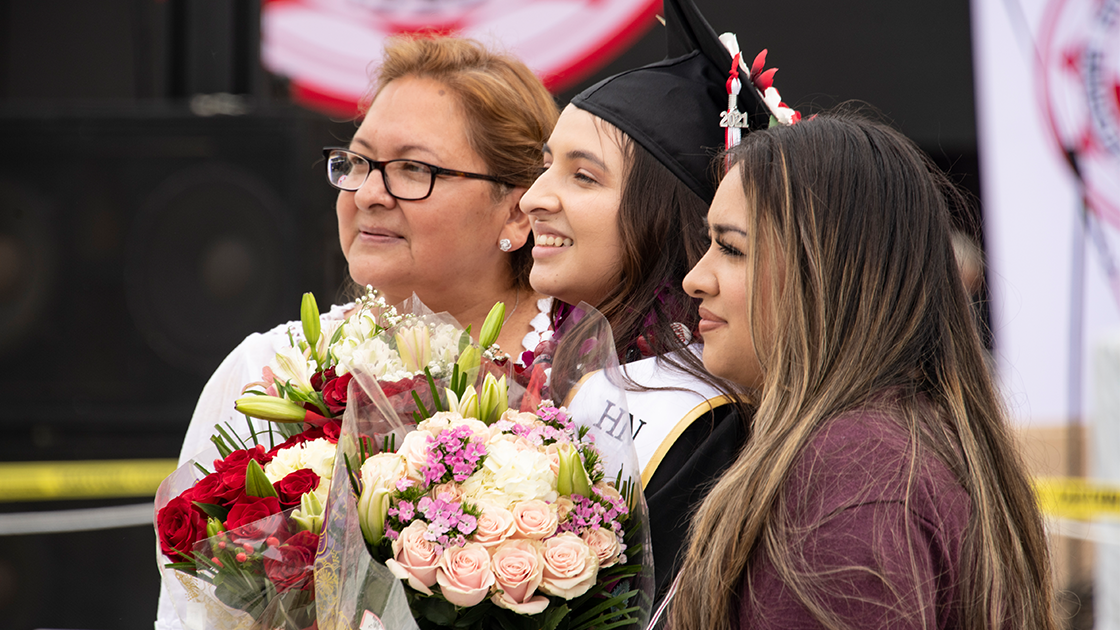 Graduate with RN stole and flowers.