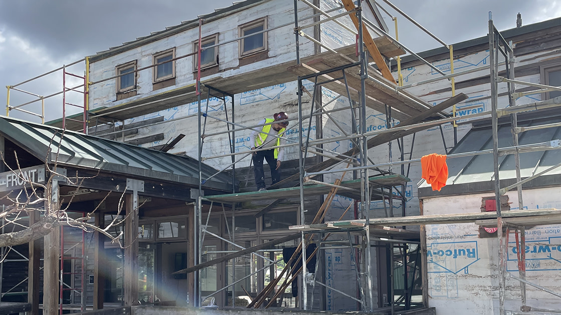 Construction crew removing old cedar siding from Riverfront housing.