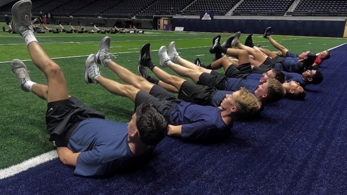 AFROTC cadets doing leg exercises on an indoor field.