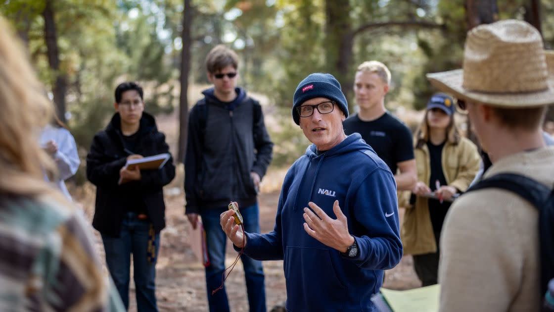 An NAU Forestry professor lecturing to students in a class outdoors.