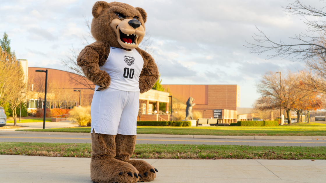 Grizz standing with his hands on his hips with the O'Rena in the background.