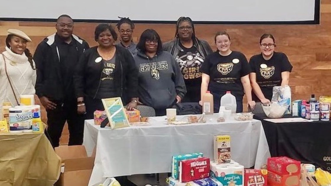 Students gather around a table collecting items for the Good Pantry in the Oakland Center.