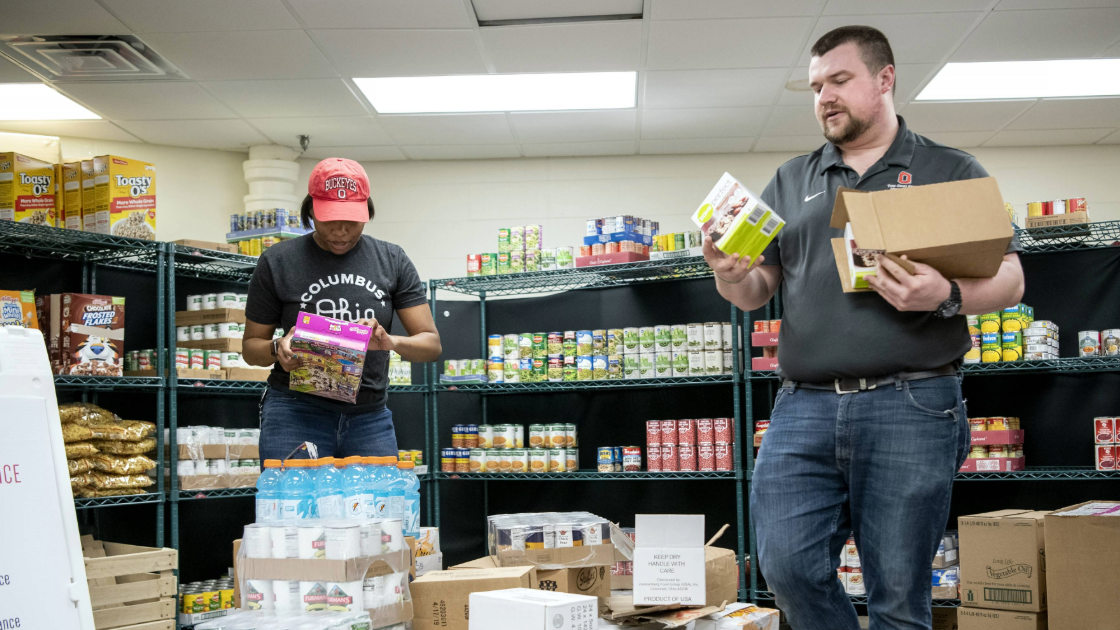 Two individuals in Ohio State clothing in food pantry
