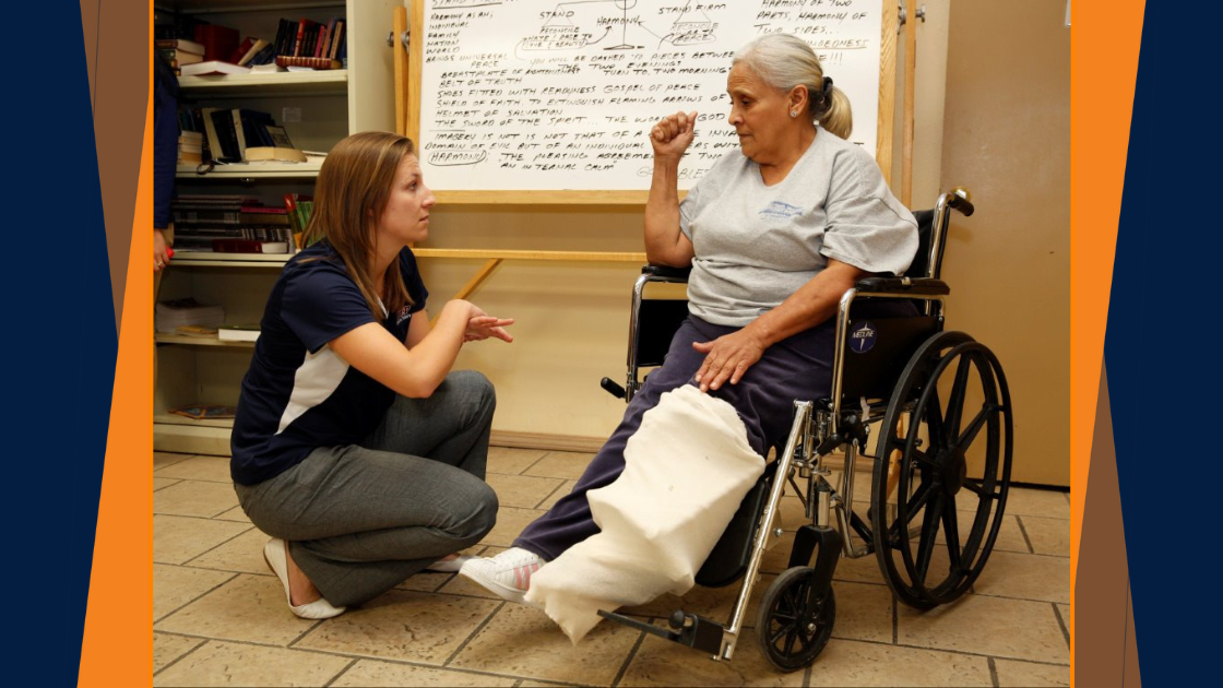 Occupational Therapy Student Talking to Patient with Leg Cast in Wheelchair