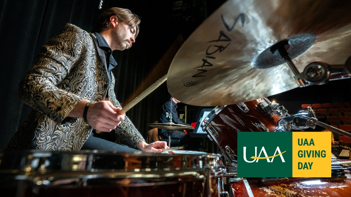 UAA Student on drums as UAA Jazz Ensemble and student singers prepare for a performance