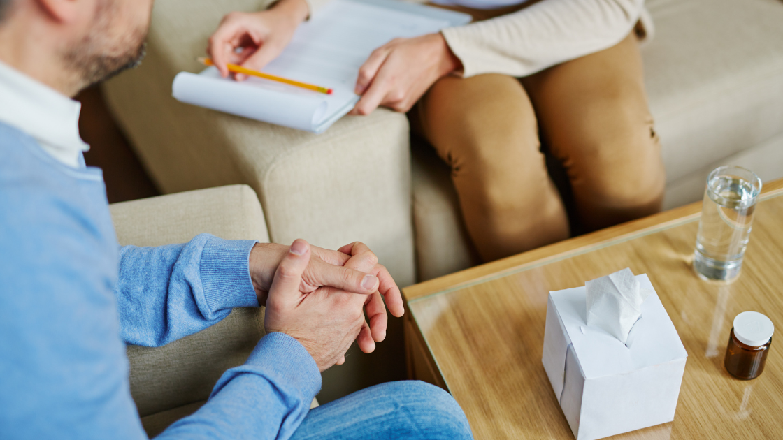 A close-up shot of a therapist taking notes during a session with a patient.