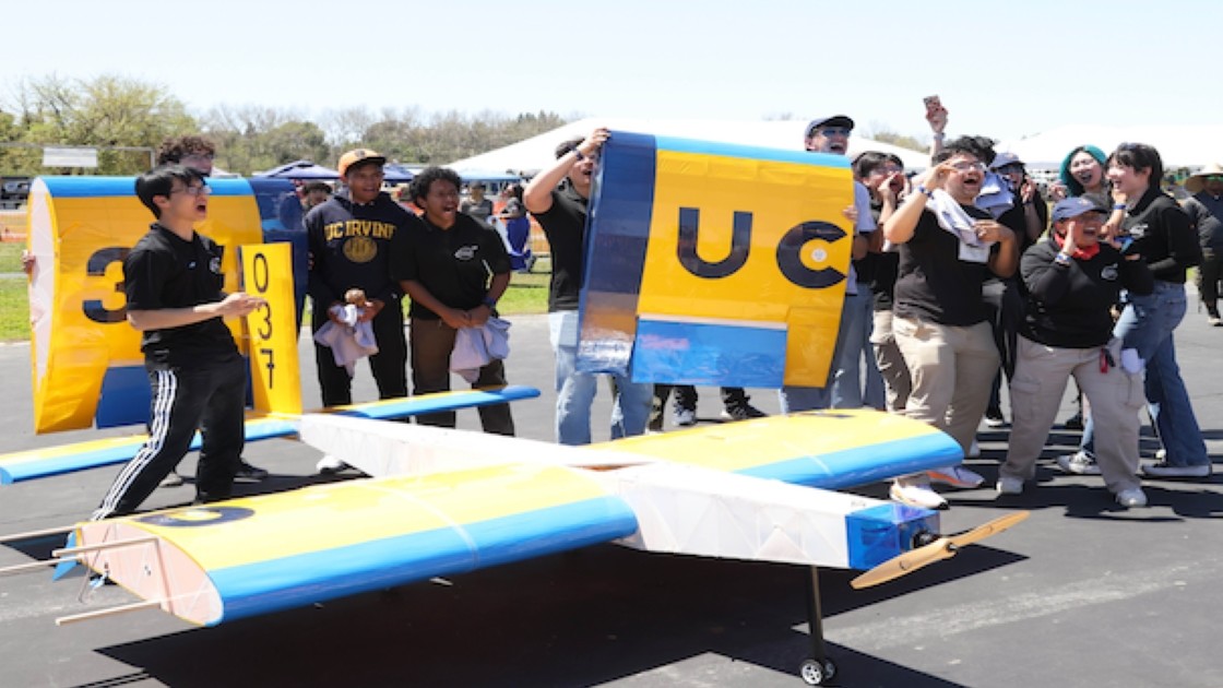 Remote-controlled cargo plane in flight against a clear blue sky