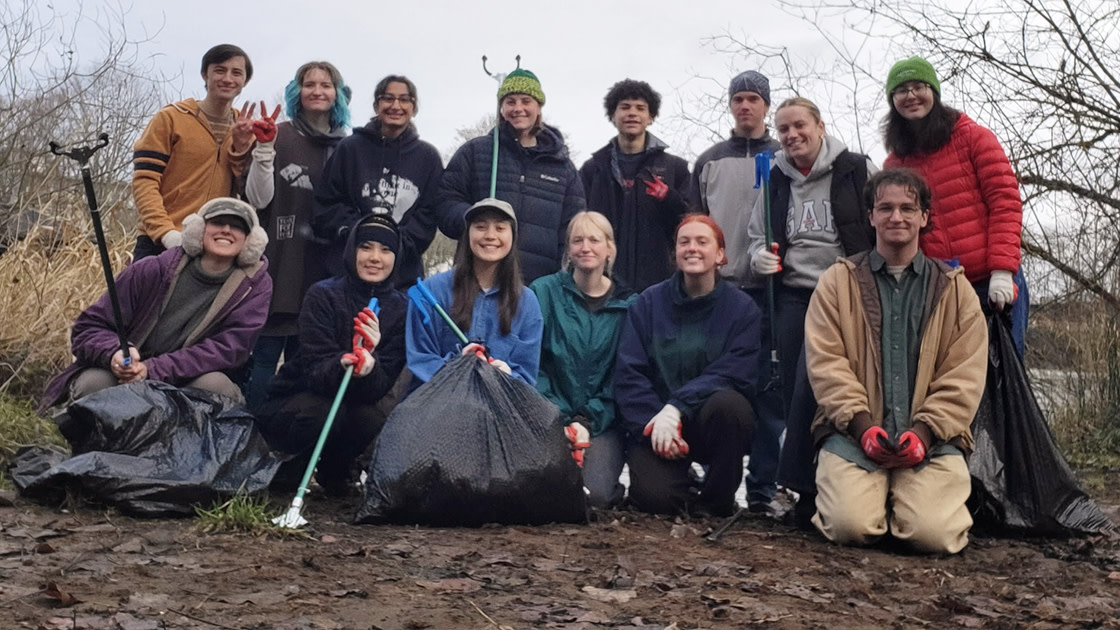 Wayne Morse Scholars volunteer together to clean up trash near the river.