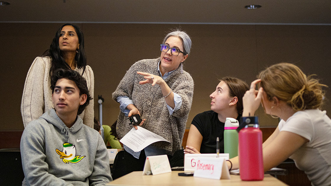 Two female professors presenting to a group of three students