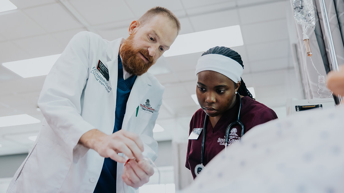 Clinical instructor teaching student during a simulation
